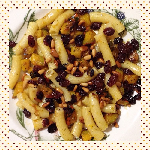 Pasta servida con un salteado de piñones y pasas.